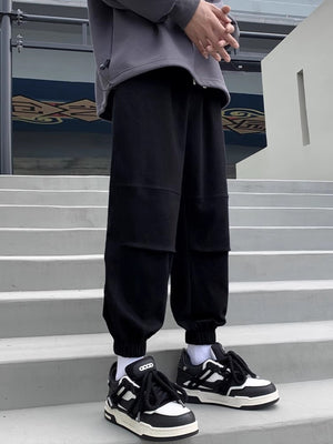 Black relaxed fit joggers with panel details and cuffed ankles.