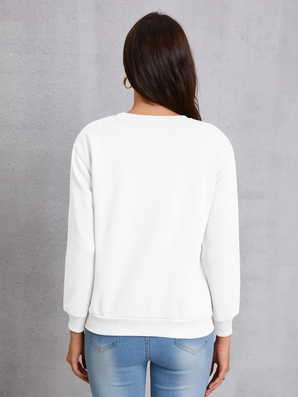 White crewneck sweatshirt with long sleeves and ribbed cuffs and hem.