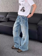 Distressed wide-leg denim jeans with chain detail and ripped accents.