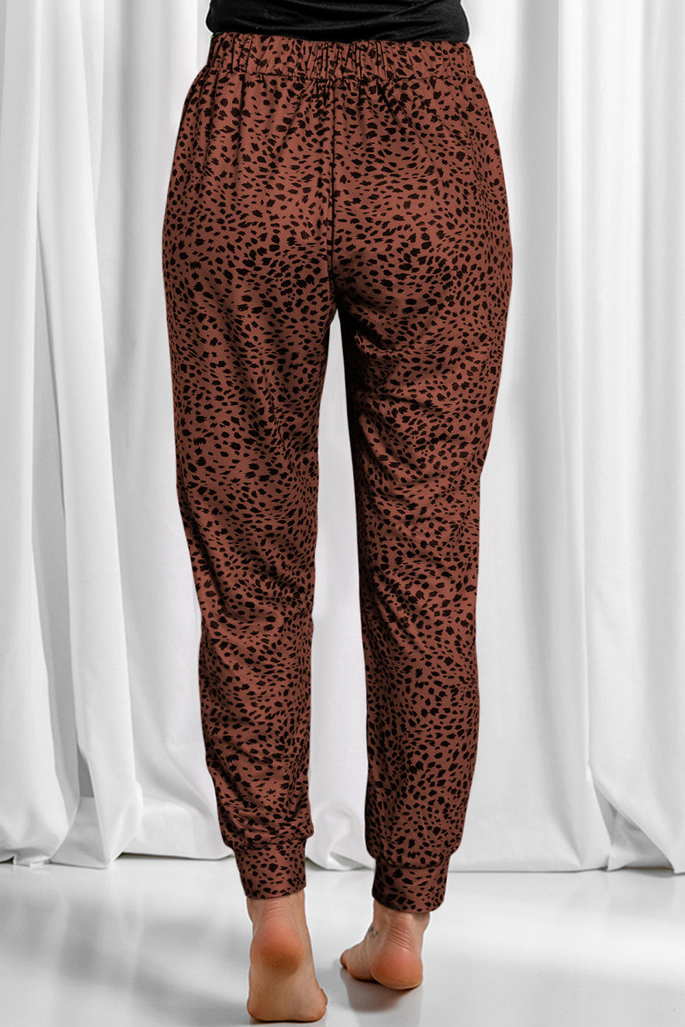 Brown leopard print jogger trousers with elastic waistband and cuffed ankles.