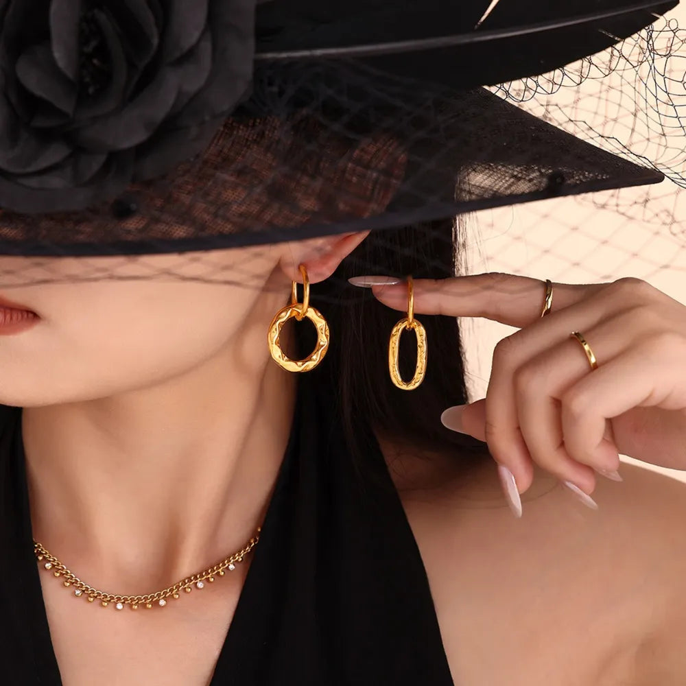 Textured gold vermeil hoop earrings, one circular and one oval, with a subtle hammered finish.