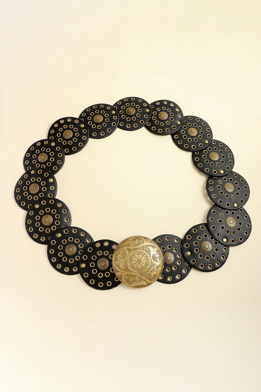 Black leather belt with round gold-tone disc embellishments and a large ornate gold buckle.