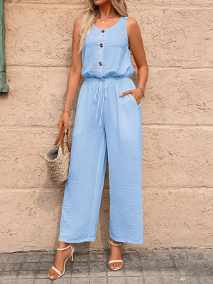 Sky blue wide-leg romper with button detail, drawstring waist, and textured fabric.