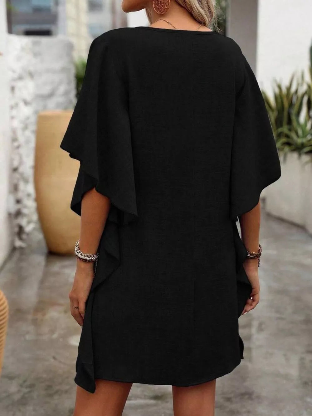 Black mini dress with ruffled sleeves and V-neck, casual style.