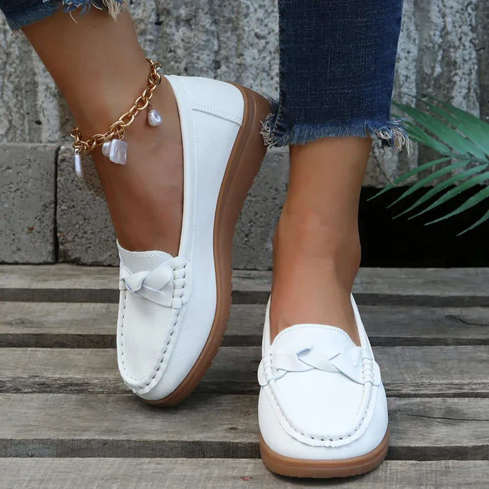 White leather loafers with braided detail and contrast stitching.