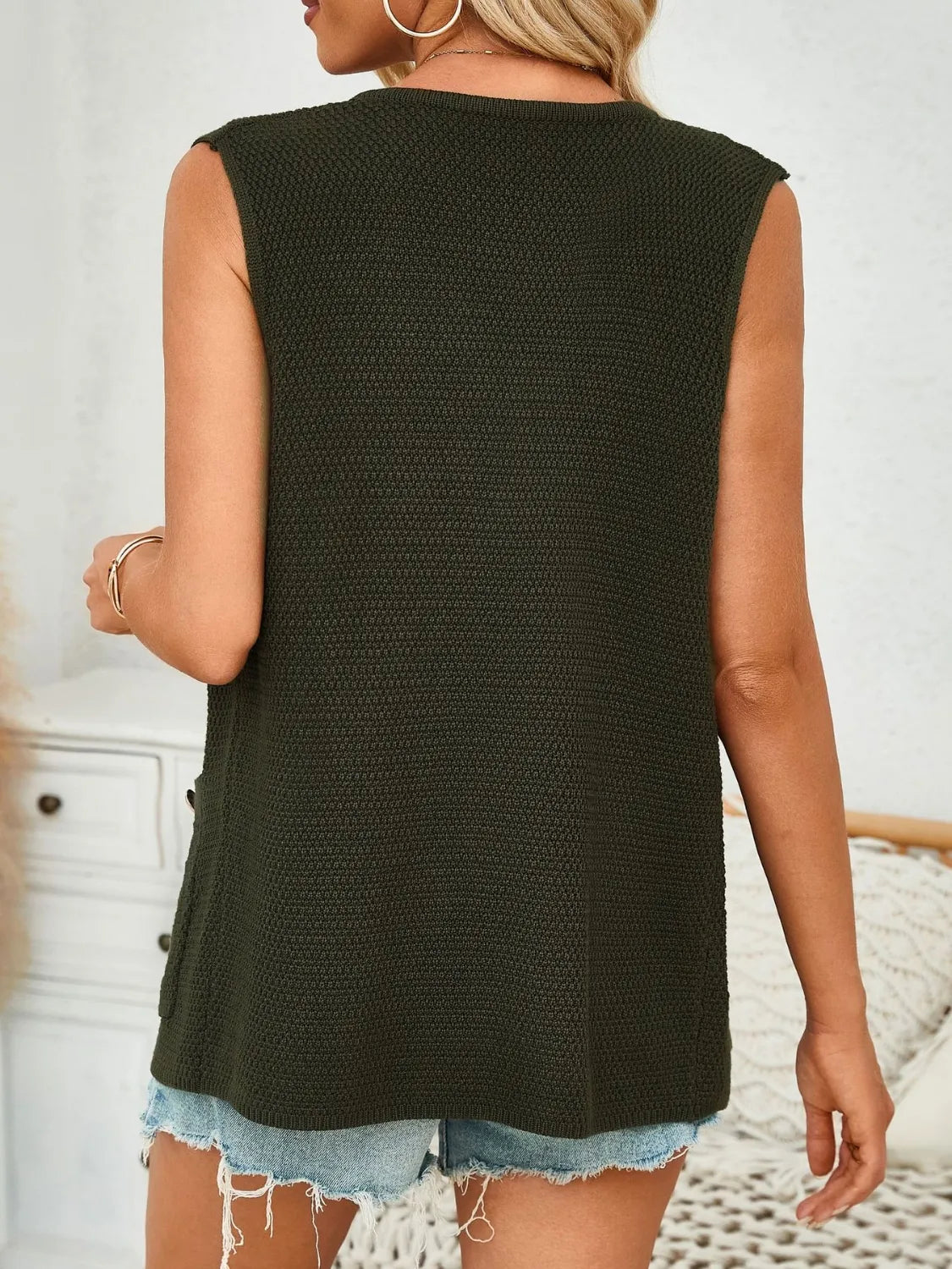 Buttoned knit pocket vest in Black Forest with a textured pattern and button details.