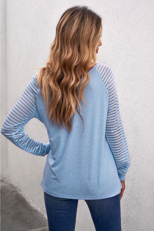 Light blue raglan sleeve top with sheer stripe detail on sleeves