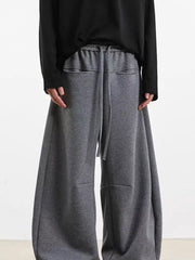 Men's gray wide-leg sweatpants with drawstring and pockets.