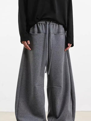 Men's gray wide-leg sweatpants with drawstring and pockets.