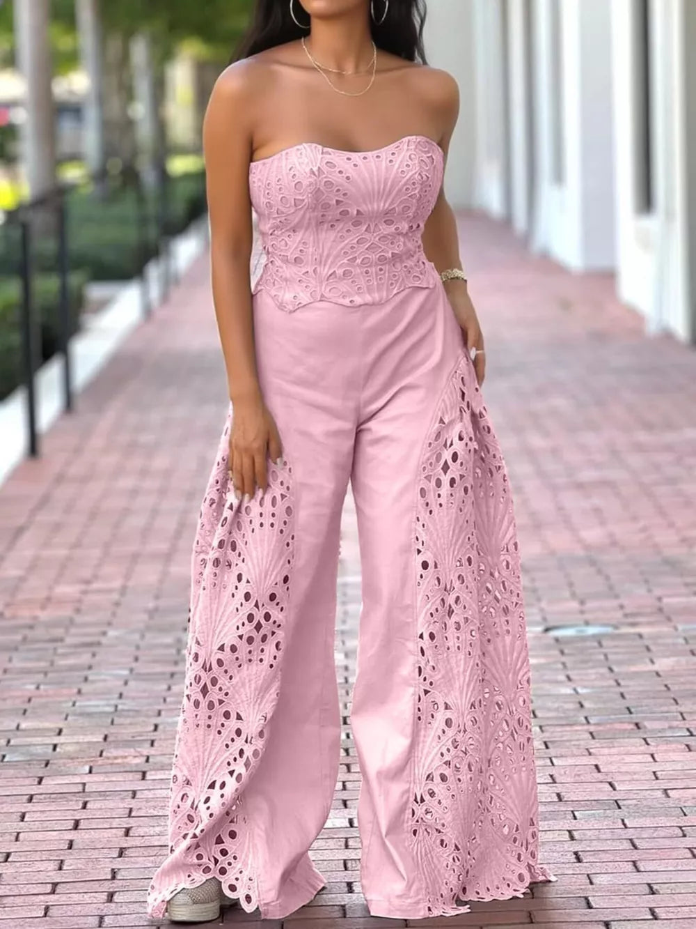 Pink strapless openwork two-piece ensemble with wide-leg pants and intricate detailing.