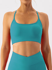 Teal ribbed halterneck active bra with a scoop neckline and thin straps.