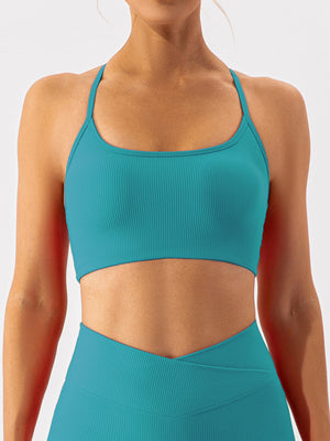 Teal ribbed halterneck active bra with a scoop neckline and thin straps.