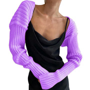 Lavender ribbed knit shrug with extended sleeves, worn over a black slip dress.