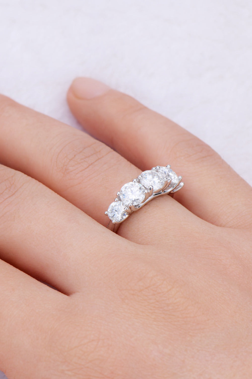 Silver five-stone moissanite eternity band ring with round cut stones.