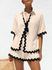 Tan pajama set with black wavy trim on collar, sleeves, and shorts.