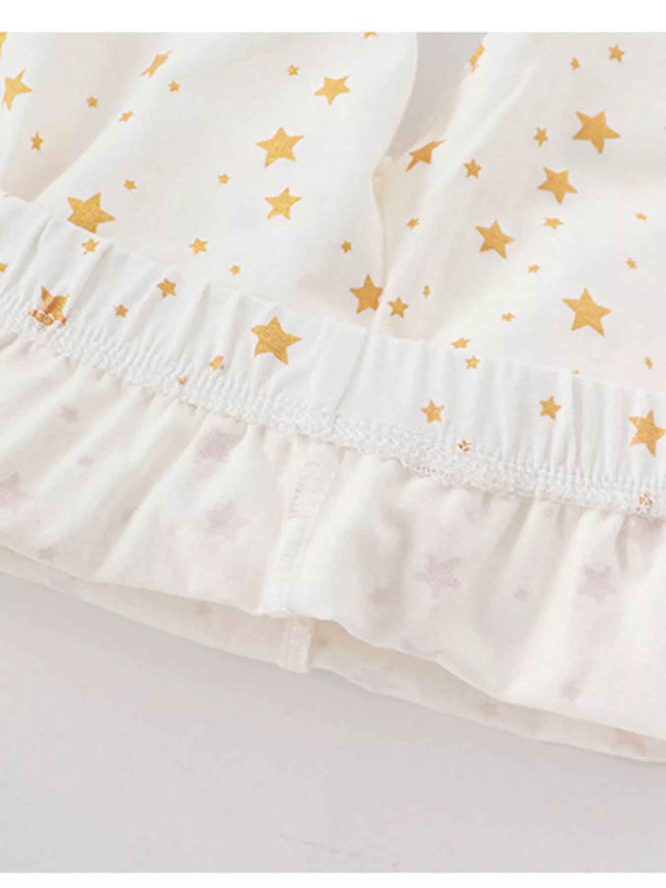 Baby girls' pajama shorts in blush pink with gold stars and ruffled hem