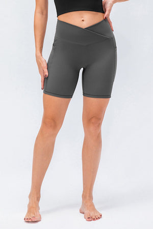 Cross-waist bike shorts in dark gray with side pockets.