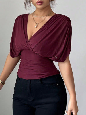 Burgundy ruched surplice dolman sleeve tunic with a deep V-neckline.