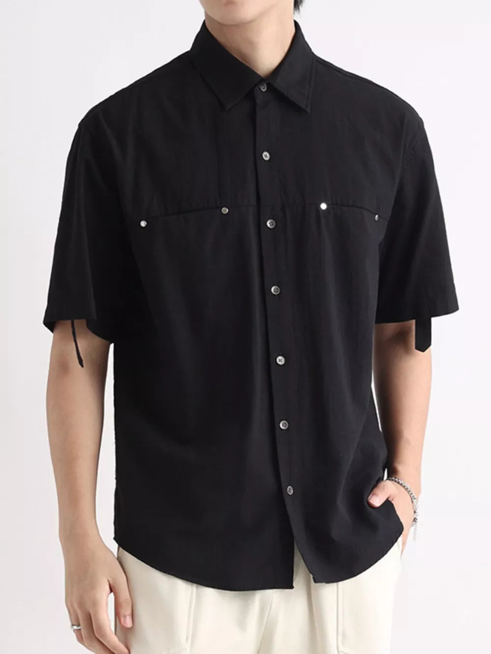 Black relaxed-fit cotton button-down shirt with short sleeves and chest pockets.