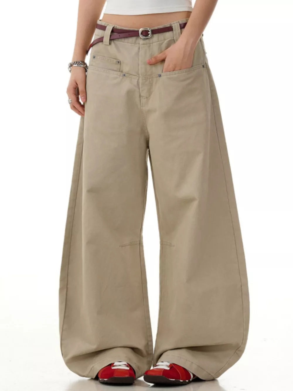 Khaki wide-leg sweatpants with pockets and a belt, styled with red sneakers.
