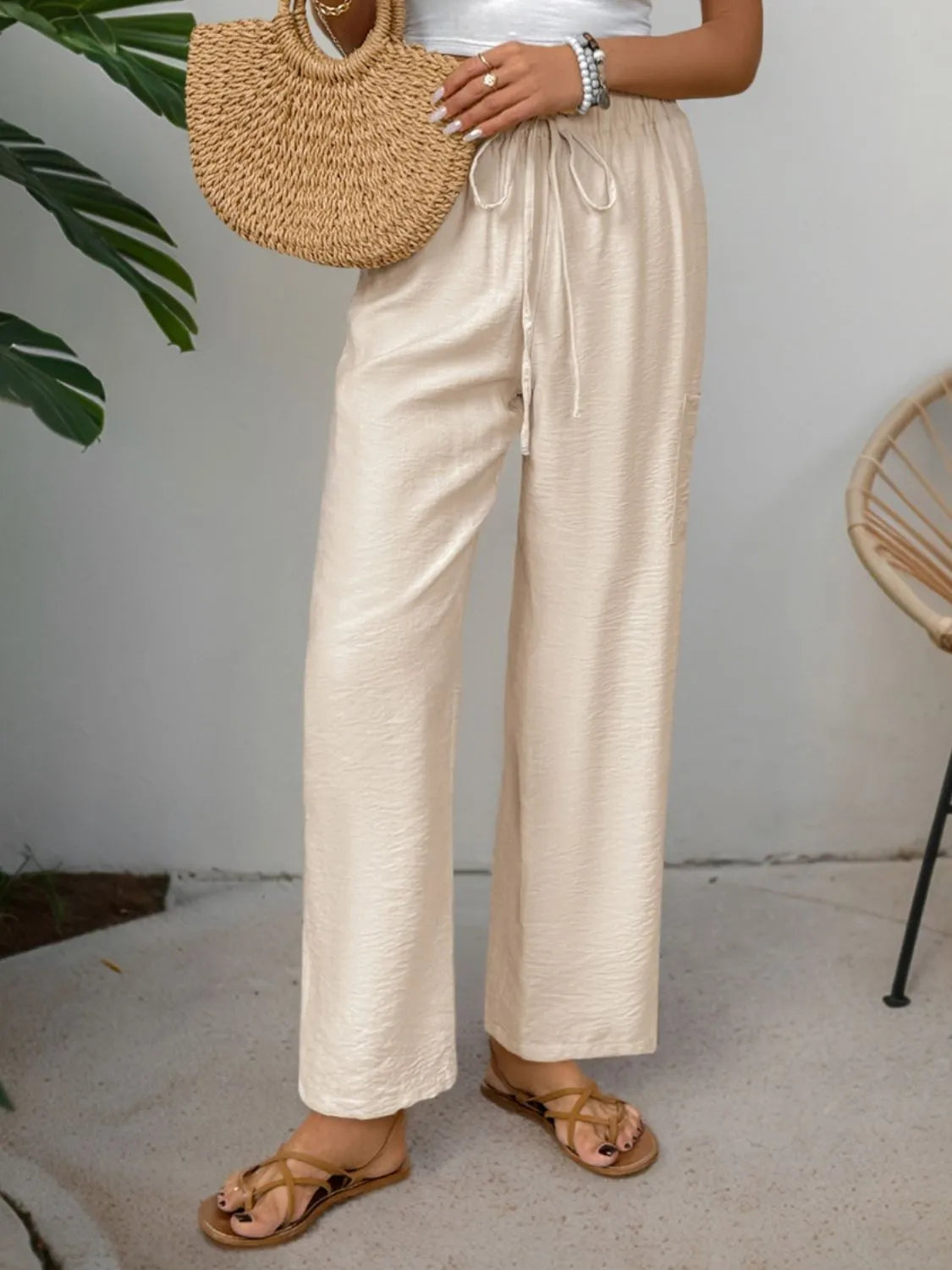 Chic tan waist-tie flare trousers with a relaxed fit and textured fabric.