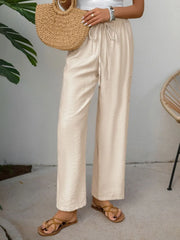 Chic tan waist-tie flare trousers with a relaxed fit and textured fabric.