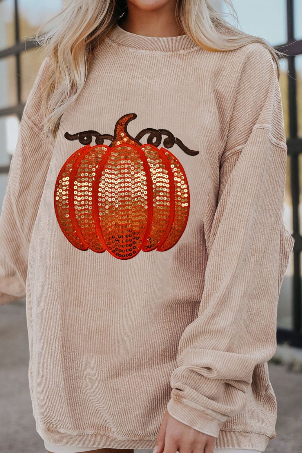 Relaxed fit corduroy sweatshirt in Sherbet with a sequin pumpkin graphic and crew neck.