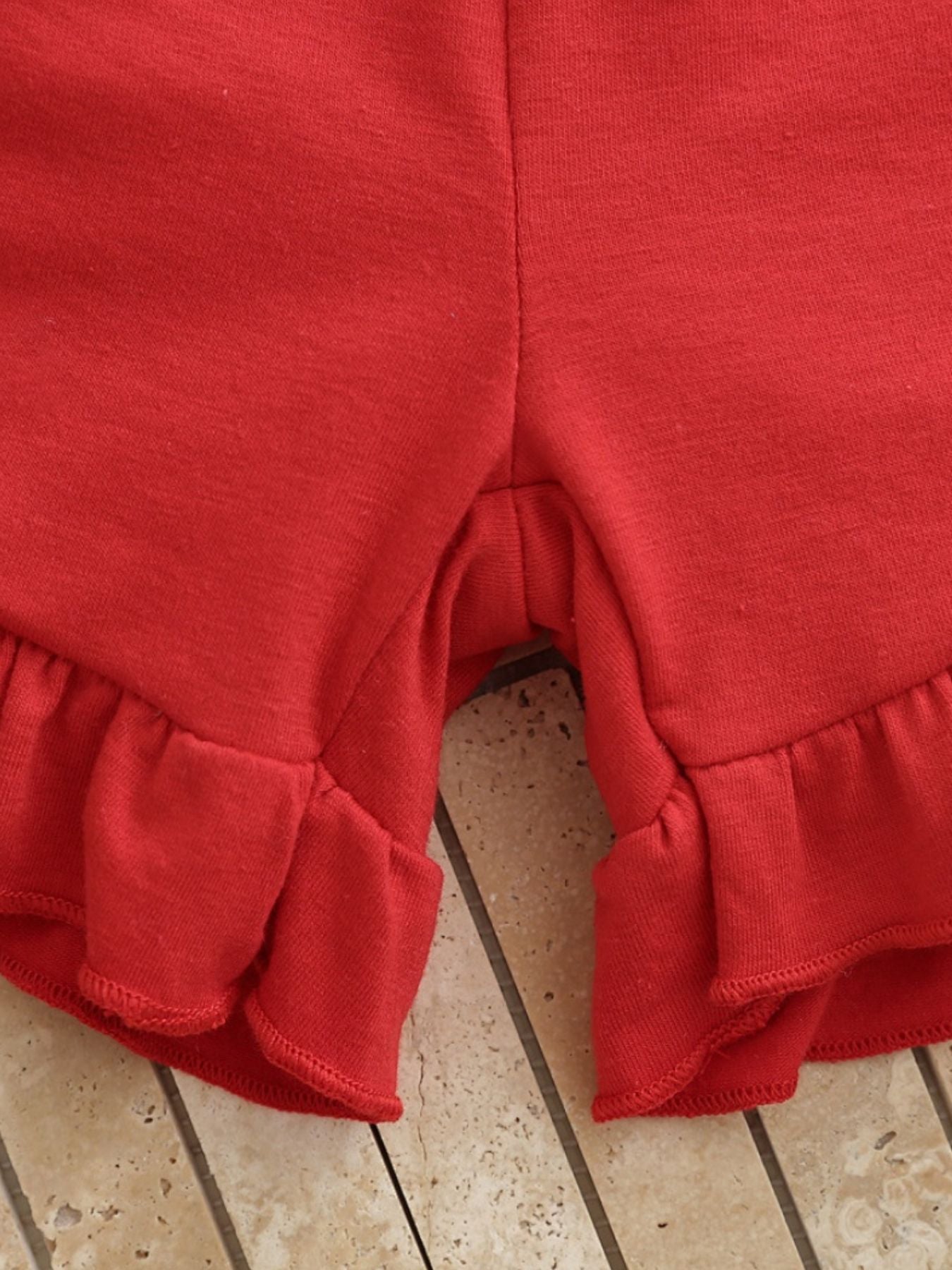 Red cotton baby shorts with ruffled hem detail