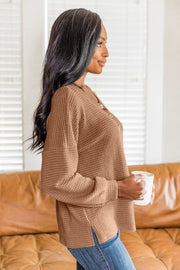 Camel waffle knit henley pullover with button detail and side slits.
