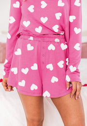 Hot pink heart print pajama set with long sleeve top and elastic waist shorts.