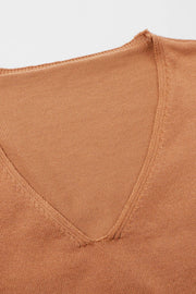 Relaxed V-neck knit poncho top in caramel with a textured knit and raw edge neckline.