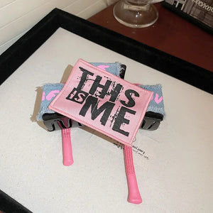 Denim patchwork claw clip with pink "THIS IS ME" patch and drawcord detail.