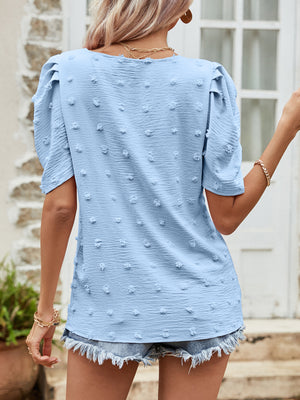 Blue textured dotty puff sleeve blouse with a V-neck.