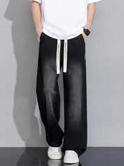 Men's black relaxed fit wide-leg jeans with drawstring waist and vintage wash.