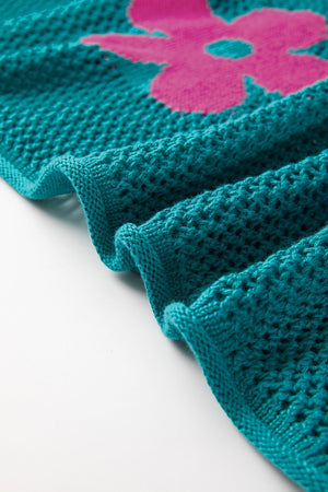 Openwork floral intarsia sweater in teal with a pink flower detail and textured knit.