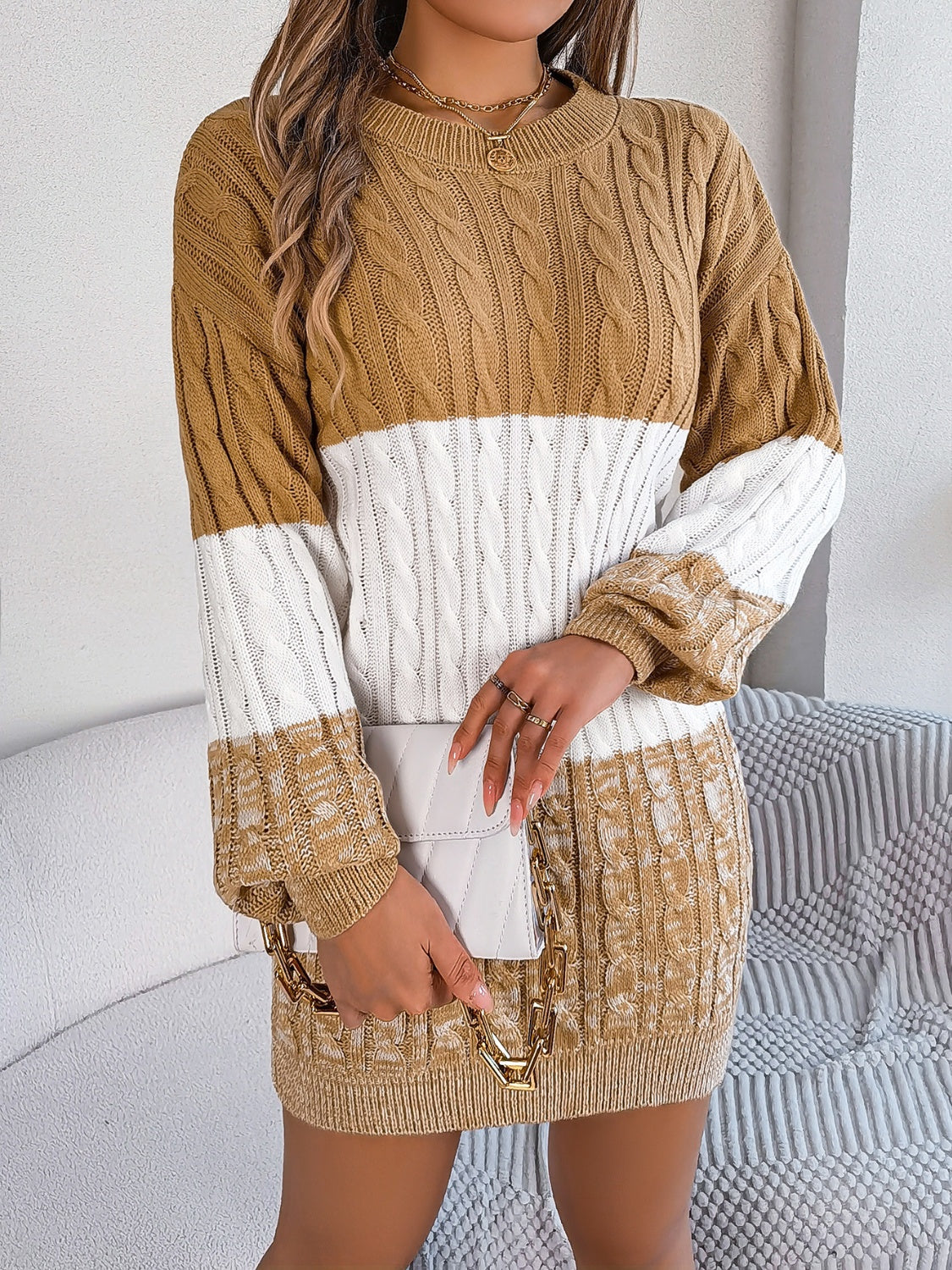 Colorblock cable knit mini dress in camel and white acrylic with crew neck and long sleeves.