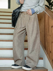 Men's wide leg trousers in beige with a belted waist and pockets.