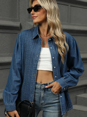Navy denim shirt with puffed sleeves, pleats, and buttons.