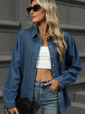 Navy denim shirt with puffed sleeves, pleats, and buttons.