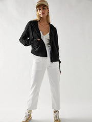 Black waffle knit cropped hoodie with snap front and hood, styled with white pants.
