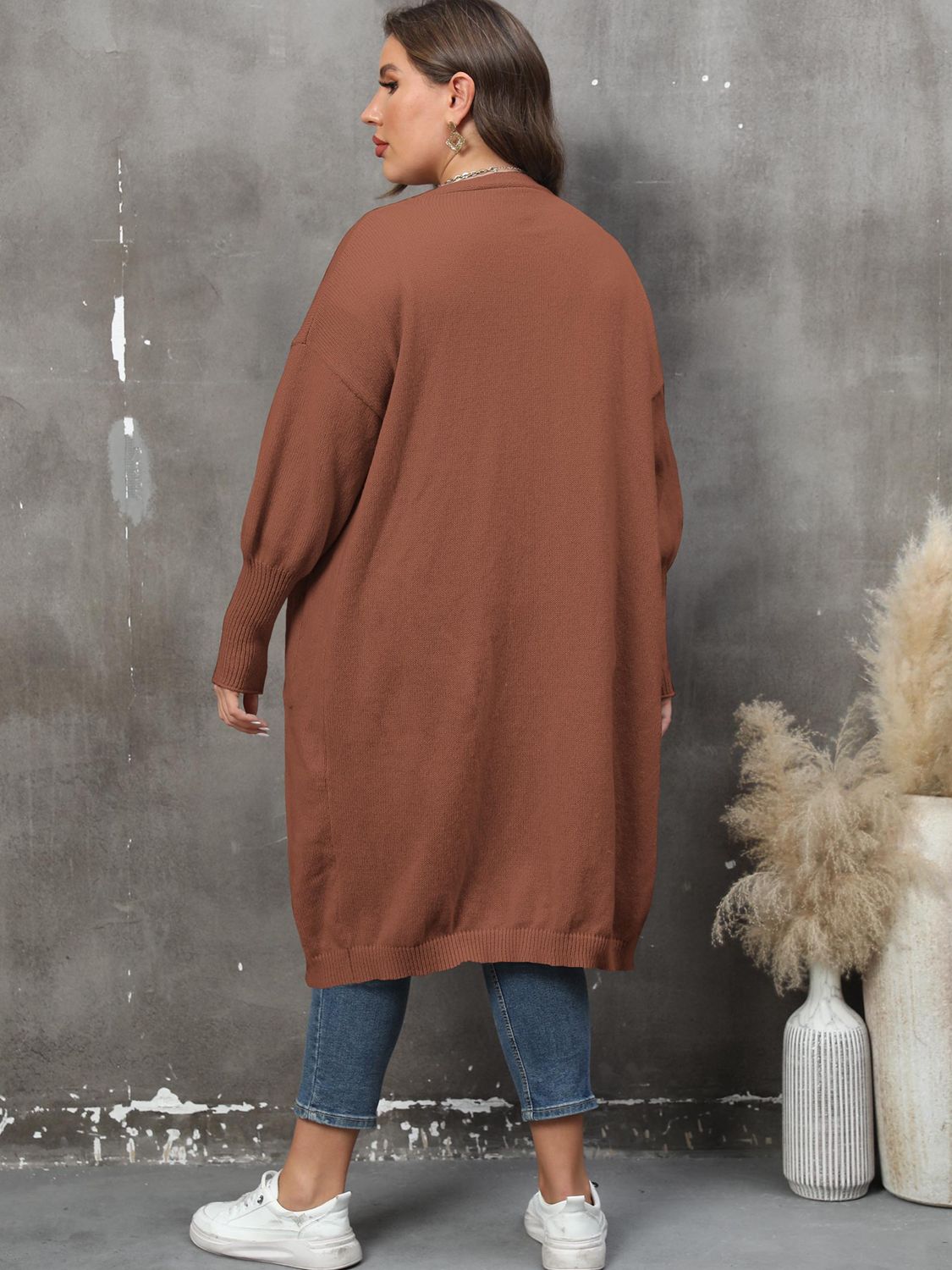 Brown oversized knit duster cardigan with patch pockets and long sleeves.