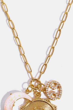 Gold celestial pendant necklace with Cancer zodiac sign charm and opal moon charm.