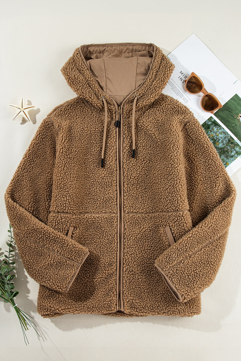 Brown sherpa hooded jacket with contrast lining and zip closure.