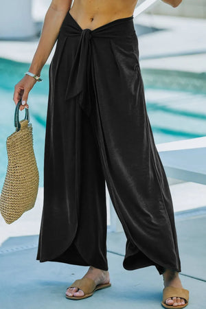 Black wrap-front palazzo pants with slit hem and tie waist detail.