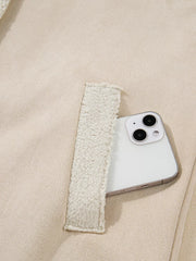 Lined western jacket in eggshell with sherpa-lined pocket detail holding a smartphone.