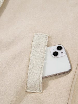 Lined western jacket in eggshell with sherpa-lined pocket detail holding a smartphone.