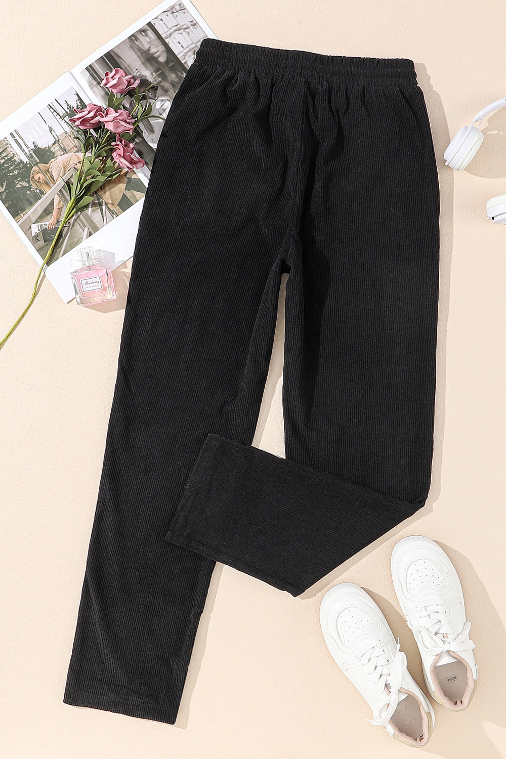 Black corduroy drawstring trousers with a relaxed fit and visible ribbing.