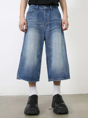 Wide-leg denim culotte shorts in blue wash with a relaxed fit and buttoned front.