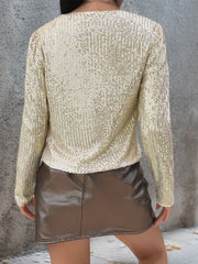 Gold sequin bolero jacket with long sleeves and puffed shoulders.