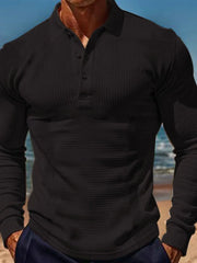 Black textured waffle knit long-sleeve polo shirt with a button placket.